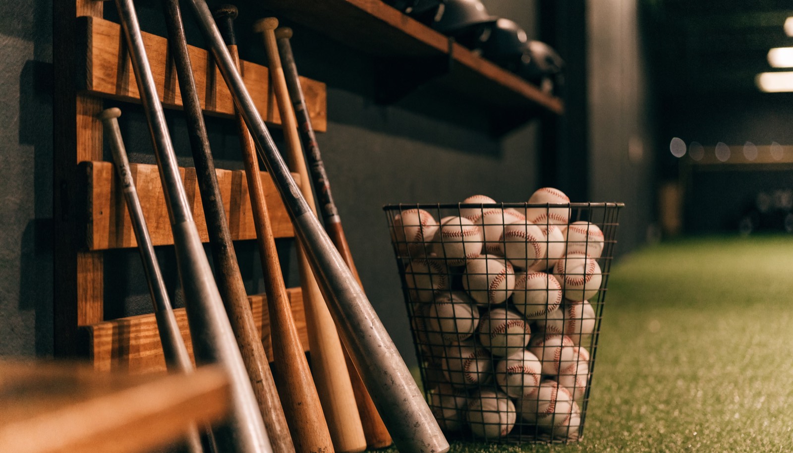 A rack of baseball bats and a basket of balls